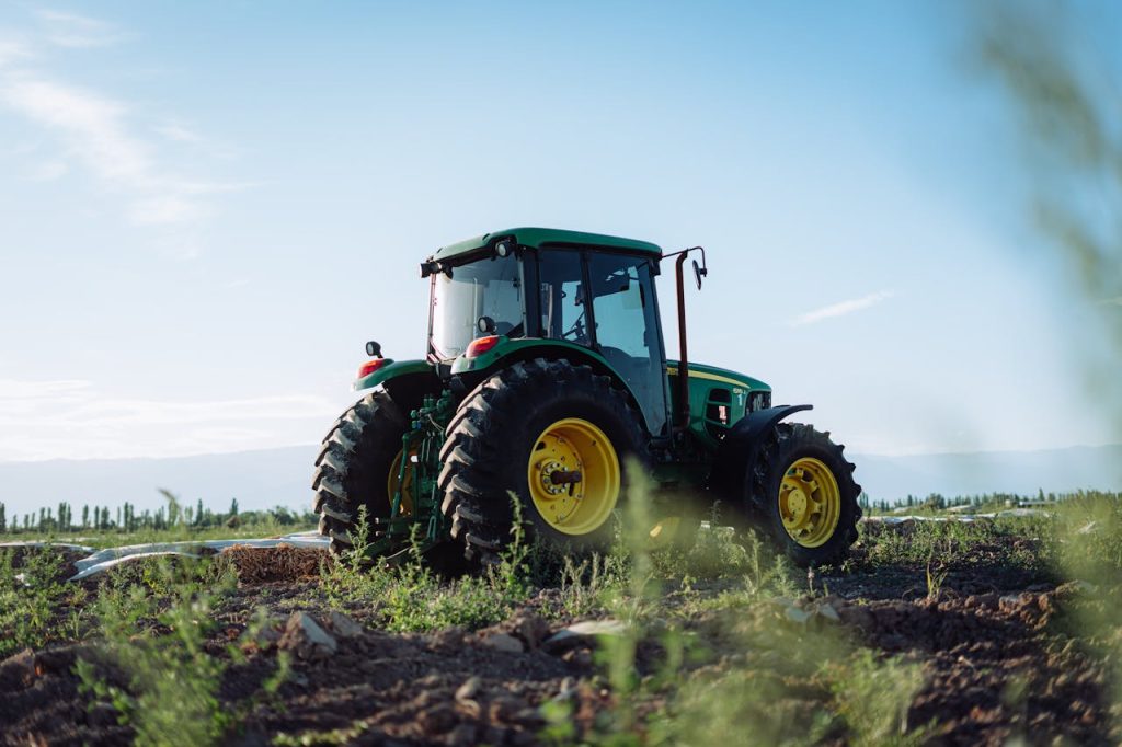 green-tractor-in-mendoza-farmland-29465456 A vibrant green tractor on a farm in Mendoza, Argentina, under clear blue skies.